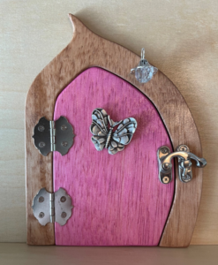 bubblegum pink handcrafted faerie door with butterfly charm and brown frame