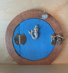 sky blue hobbit shaped handcrafted faerie door with mermaid charm and brown frame