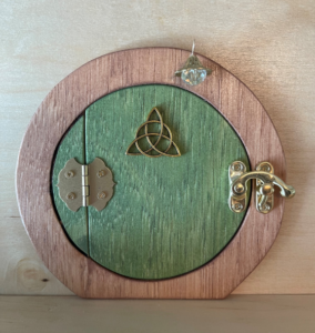 green hobbit shaped handcrafted faerie door with brown frame