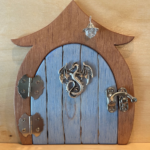 light blue handcrafted faerie door with dragon charm and brown frame