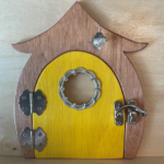 bright yellow handcrafted faerie door with window and brown frame