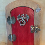 red handcrafted faerie door with dragon charm and brown frame