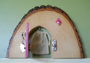 handcrafted open wooden faerie door with small bag inside
