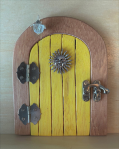 yellow handcrafted faerie door with brown frame