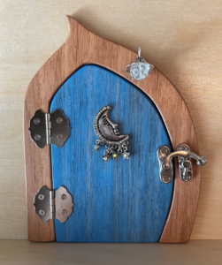 ocean blue handcrafted faerie door with moon charm and brown frame
