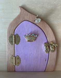 orchid handcrafted faerie door with crown charm and brown frame'