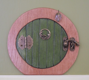 Green hobbit shaped handcrafted faerie door with pink frame