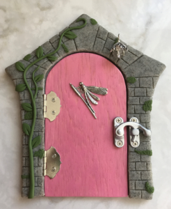 pink handcrafted faerie door with stone frame