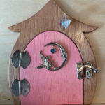 pink handcrafted faerie door with moon charm and brown frame