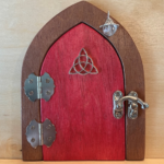 red handcrafted faerie door with brown frame