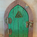 green handcrafted faerie door with brown frame