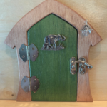 green handcrafted faerie door with elephant charm and brown frame