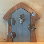 blue handcrafted faerie door with faerie charm and brown frame